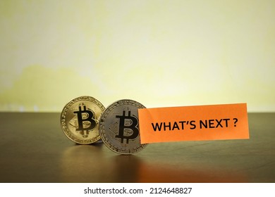 Bitcoin with message on What's Next? written on the sticky notes. Noise and grain is visible due to low light photography. Business concept