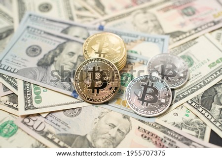 Bitcoin on top of United States dollar banknotes. Fiat currency and Cryptocurrency concept. 100 dollar bills and 50 dollar banknotes with golden and silver BTC coins