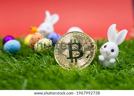 Bitcoin with rabbit for Easter Holiday with eggs on green grass