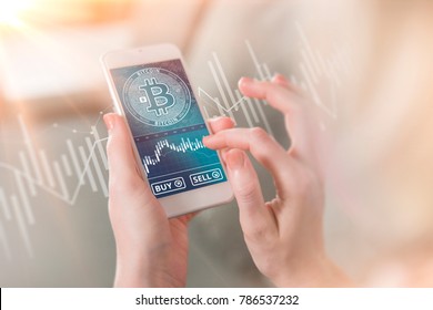 Bitcoin symbol on mobile app screen with big BUY and SELL buttons. Bitcoin on stock market. New digital money.