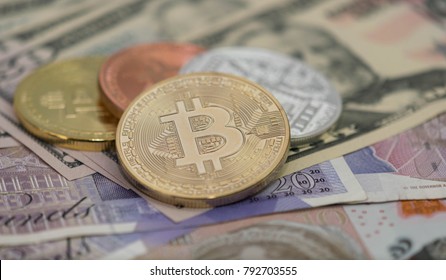 Bitcoins with US banknotes and british banknotes, 20 pounds sterling, 10 pound sterling notes. golden bitcoin, silver bitcoin, bronze bitcoin