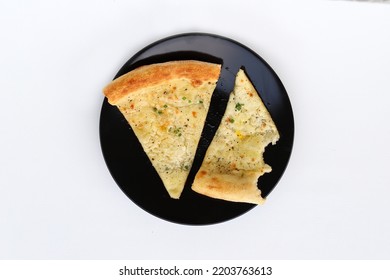 Bites And A Slice Of Cheese Pizza Served On Black Plate Isolated On White Background