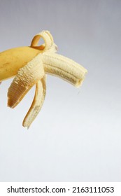 a bitten banana in a peel on a white background. ripe fruit.
