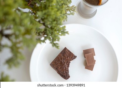 Bitten Brownies And Black Chocolate In A White Plate,Top View