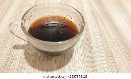 bitter black coffee in a clear glass on a wooden table - Powered by Shutterstock