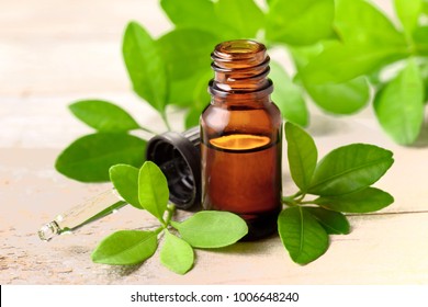 Bitter Orange Leaf Essential Oil And Glass Dropper On The Wooden Board