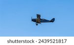 A bi-wing, De havilland Fox Moth. flying at an airshow.  