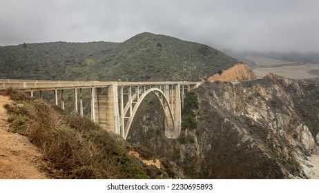 The Bixby Bridge in the Big Sur coastal area with steep cliffs nearby in the US state of California on a cloudy foggy day. - Powered by Shutterstock