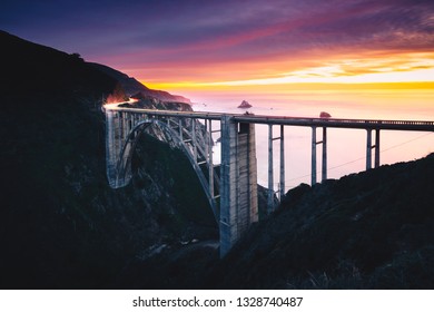 Bixby Creek Bridge With Colorful Sunset And Car Light Trails, Big Sur, CA