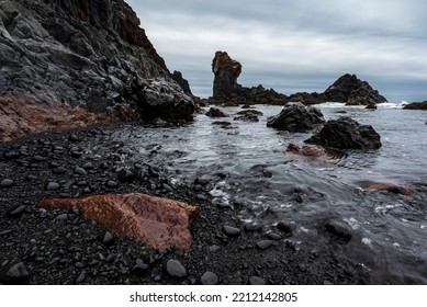 Bizarre black basalt rock formations and volcanic lava boulders in the surf on the shore of Djúpalónssandur beach, Snæfellsnes, Iceland