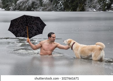 Bizarre Picture Of A Man Holiding An Umbrella And Petting A Dog In A Frozen Lake. Taken In Alice Lake, Squamish, North Of Vacouver, BC, Canada.