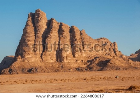 Bizarre shapes of rocks in deserted desert. Jordan. Desert of Wadi Rum. Landscape is similar to Martian landscapes. Sand is of beautiful pink color in rays of setting sun. Nature concept for design