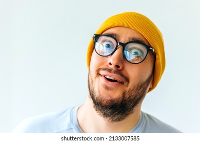 bizarre and strange bearded man with glasses and yellow hat. male face grimace looking at camera. - Shutterstock ID 2133007585