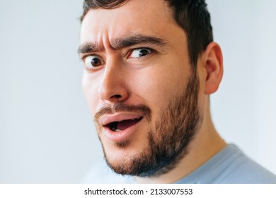 bizarre and strange bearded man. male face grimace looking at camera.