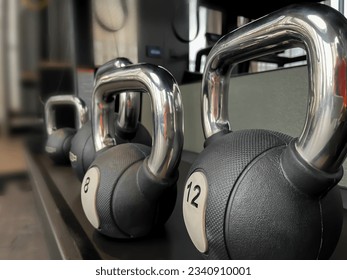 Black 12 kg kettlebells on the gym shelve. Workout equipment closeup photo, no people - Powered by Shutterstock