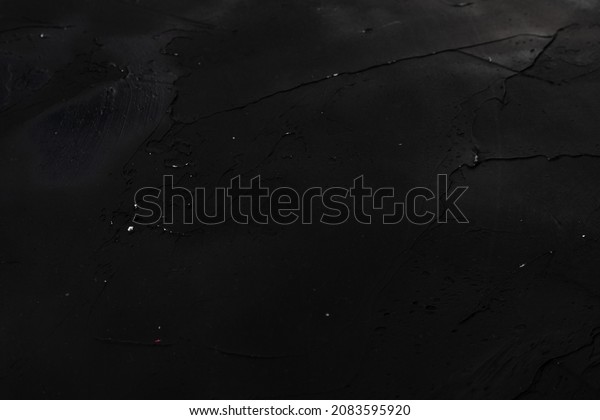 Black Abstract\
background. Macro image of spackling paste. Stroke wallpaper for\
web and game design. Drywall mud art. Smear of painterly plaster on\
cardboard.