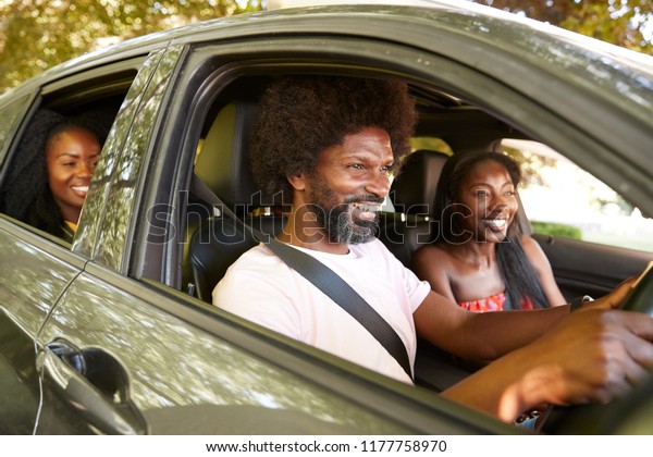 Black adult\
friends in a car during a road\
trip