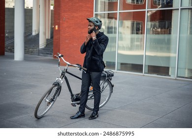 black African American businessman is depicted fastening his helmet before mounting his electric bike, preparing for an eco-friendly commute to work in the bustling financial district of the city - Powered by Shutterstock