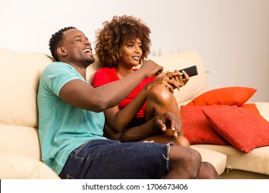 Black African American Couple Watching Tv In The Living Room