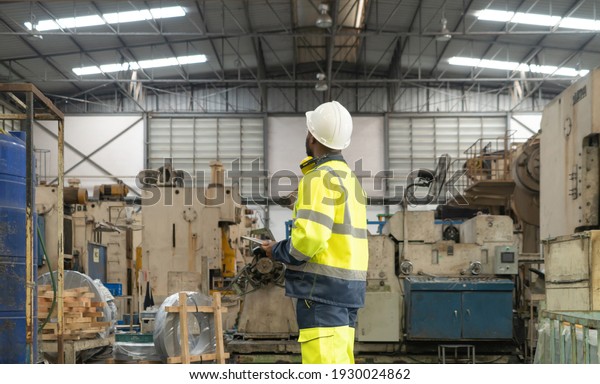 Black African American man, an engineer or\
worker working in manufacturing factory with equipment machine\
engine production system work, technology in operation in industry\
plant in warehouse