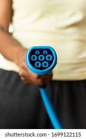 Black African American Person Holding An Ev Charging Cable