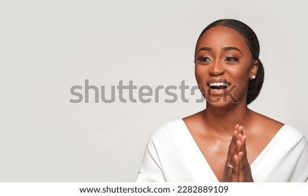 Black african american woman. Emotional portrait of a happy woman. Beauty portrait of girl with clean healthy skin on light background. Smiling dreamy beautiful afro female.