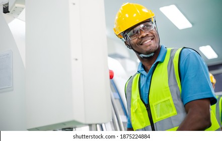 Black African American worker man control with industry machine at industrial factory. technology invention manufacturing. career and professional skill. diversity people working together. copy space