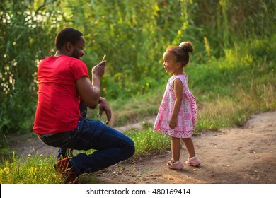 Black African father takes photo of his daughter with by means of mobile phone. - Powered by Shutterstock