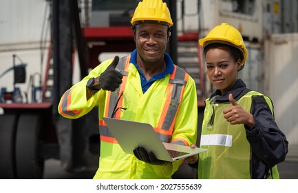 Black African male and female worker showing thumbs up with laptop working at warehouse container cargo ship import export industry - Powered by Shutterstock