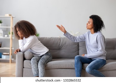 Black African Mother Scolding Teen Daughter People Sitting On Sofa At Home. Older And Younger Sisters Conflict, Teen Problems, Misunderstanding Of Different Generations, Parent Child Relations Concept