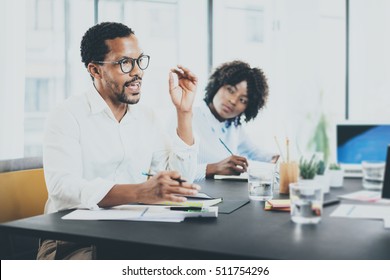 Black African Project Manager Explaning Business Task In Meeting Room.Two Young Entrepreneurs Working Together In A Modern Office.Horizontal,blurred Background