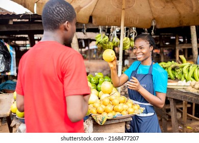 Black African Trader Selling Fruit To A Young Man