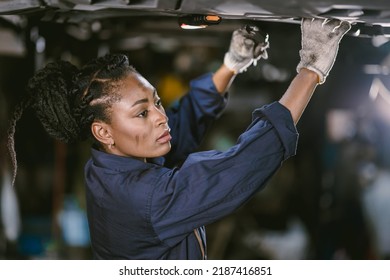 Black African Woman Mechanic Staff Worker Work Service Under Car In Dirty Garage