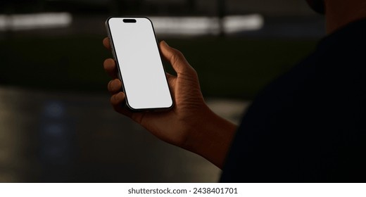 Black African-American hand displays a smartphone vertically, with a blank screen ready for app display against a night city street background, perfect for technology and urban lifestyle concepts - Powered by Shutterstock