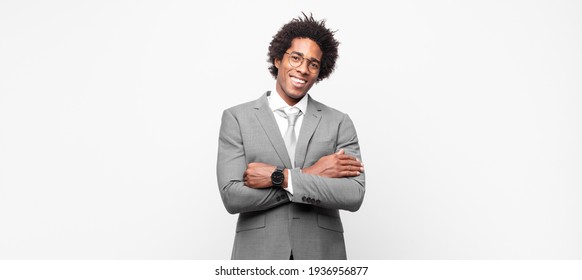 black afro businessmanlooking like a happy, proud and satisfied achiever smiling with arms crossed