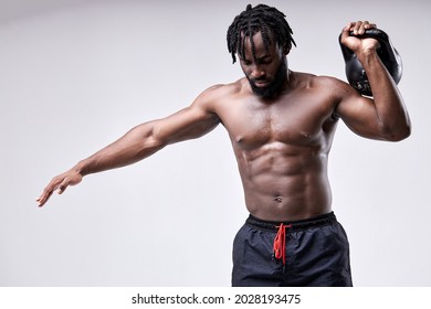 Black Afro Shirtless Man Lifting Up Kettlebell Isolated On White Studio Background. African Black Body Builder Doing Functional Training Basic Exercise. Bodybuilding, Weightlifting, Sport, Fitness