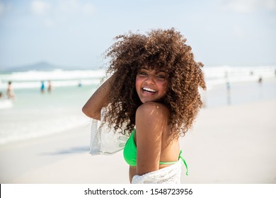 Black afro young cute girl, curly hair, bikini, beach. Afro American summer vacation holiday.
