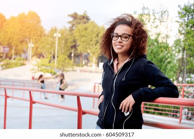 Black Afro-american Girl Listening To Music Using Earphones