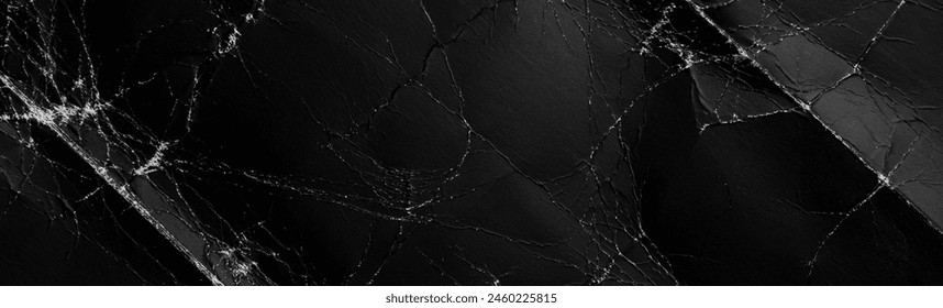 Black aged folded background with weathered wrinkles and creases. Old dark cardboard web design element