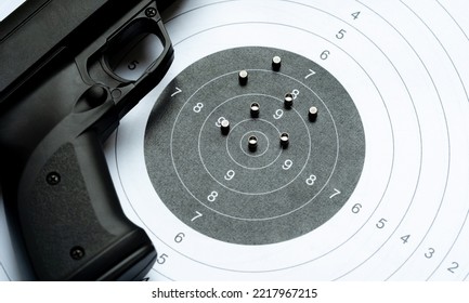 Black Air Gun Pellet Gun Laying On A Paper Shooting Target Next To A Bunch Of Steel Metal Pellets Ammunition. Airguns, Sports, Shooting Competition Aim Training Simple Concept, Nobody, No People