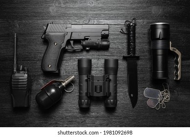 Black Airsoft Gun, Walkie Talkie Radio Station, Binoculars, Knife And Soldier Badge On The Black Flat Lay Background.