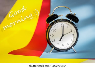 A black alarm clock indicates the time is 7:00 am and the text is good morning. Retro clock and background with place for test