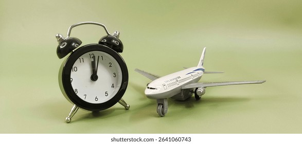 Black alarm clock with miniature airplane model representing travel planning, time management, vacation countdown, flight schedule and tourism concept. 