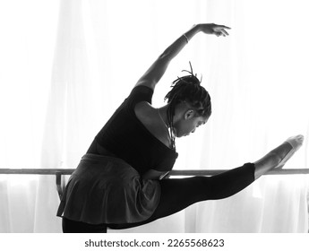 A Black American ballet dancer, stretching on the barre, at a dance studio in Bali, Indonesia - Powered by Shutterstock