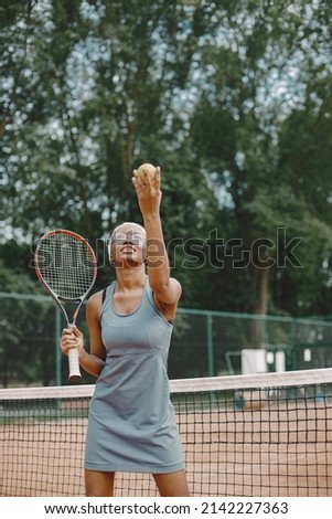 Black american female tennis player playing on the court outdoors