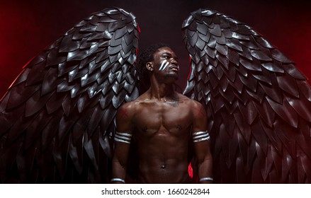 black angel suppresses a demon within every living being, african muscular man became dark angel after death, now he has big magnificent wings on back and can fly above the ground