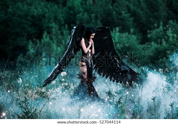 黒い天使 美しいセクシーな女の子と黒い羽と 美しい背景に魅力的なドレス 童話の古い本の画像 幻想的な撮影 ファッショナブルな撮影 クリエイティブな色 の写真素材 今すぐ編集