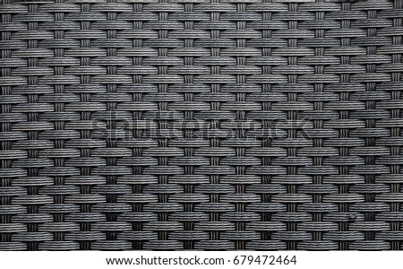 Black artificial rattan pattern. Background of basket structure close-up. Furniture backdrop