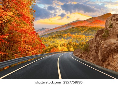 Black asphalt road landscape at sunset in beautiful colorful nature. Highway scenery among mountains in autumn season. Nature landscape on beautiful road in colorful fall. Autumn landscape in Germany.