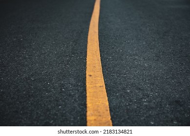 Black Asphalt Road Surface Texture With A Yellow Line.